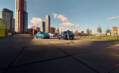 Trois véhicules Hyundai photographiés avec la ville en arrière-plan