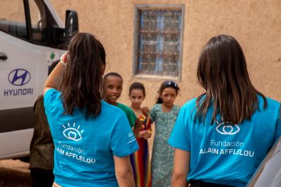 Personal de Alain Afflelou atendiendo a un grupo de niños.