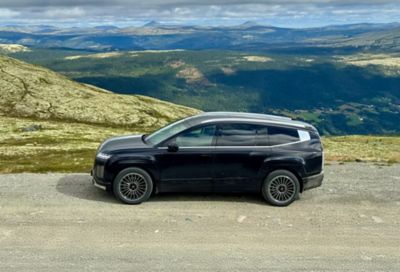 En IONIQ 5 står i et fjellandskap. Foto.