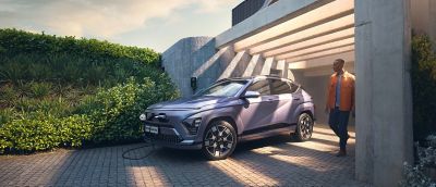 Hyundai KONA Electric elbil laddar på villauppfart.