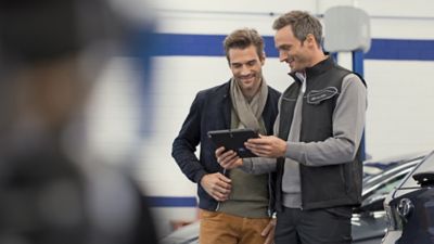 Hyundai service medewerker toont meer informatie aan een klant op een tablet.