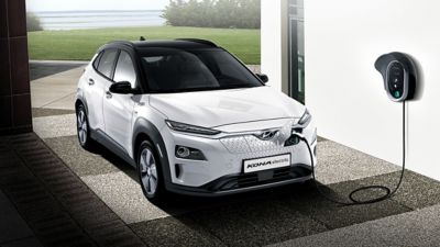 Hyundai KONA electric plugged into a wallbox in a garage