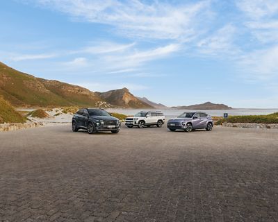 Hyundai KONA Electric Nouvelle Génération est garé à côté d'un bâtiment et deux personnes discutent à ses côtés.