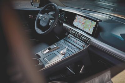 Blick auf den Fahrerbereich im Innenraum eines Hyundai – mit Mittelkonsole, Touchscreen und Lenkrad.