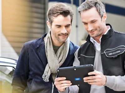 Customer and Hyundai technician looking at tablet