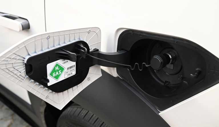 Hyundai hydrogen-powered vehicle shown at a fueling station, promoting clean energy solutions.