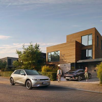 IONIQ 5 og IONIQ 6 parkert ved et hus. Foto.