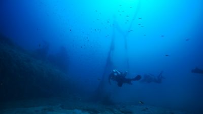 Deux plongeurs de Ghost Diving récupérant des déchets marins sous l’eau