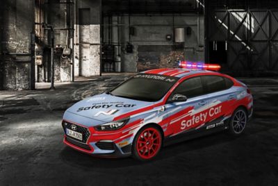 Imagen de todas las motos frente al coche de seguridad oficial Hyundai i30 Fastback N.