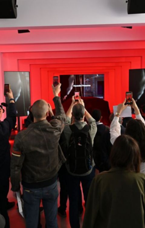 Mensen die IONIQ 3 onthulling filmen met smartphones