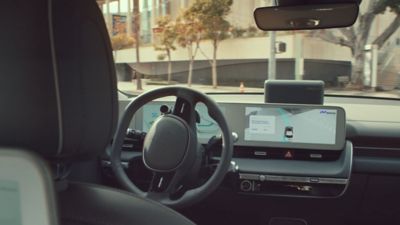 Interior del robotaxi Hyundai IONIQ 5 mostrando el volante y la pantalla central.