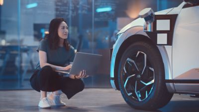 A woman checking technical car data on her computer.