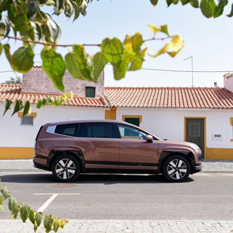 IONIQ 6 N Line cervenej farby stojaci pred modernou budovou