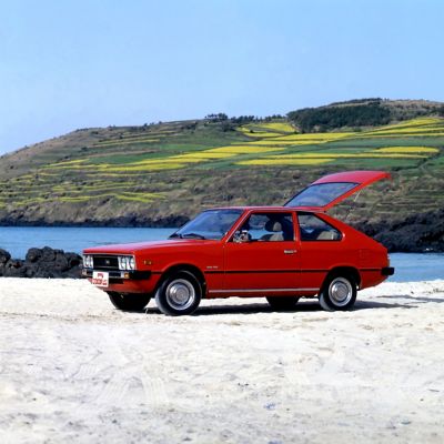 Rode Hyundai Pony driedeurs met achterklep open.