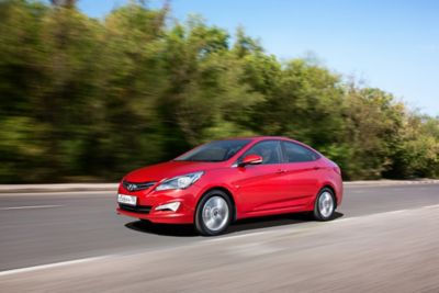 Rode vierdeurs Hyundai Solaris (2014-2017), rijdend van rechts.