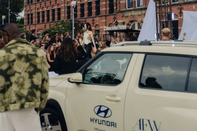 Model lopend op catwalk Amsterdam Fashion Week met op voorgrond een Hyundai INSTER.