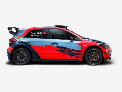 Photo of the i20 R5, shown from the rear and side, with visible spoiler and orange-blue painting.	
