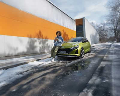 Hyundai TUCSON Hybrid garé dans une allée enneigée devant une maison décorée pour noël