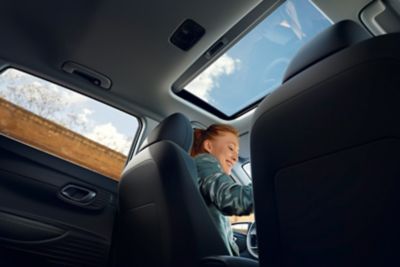 View through the Hyundai i20's open sunroof from the back seat
