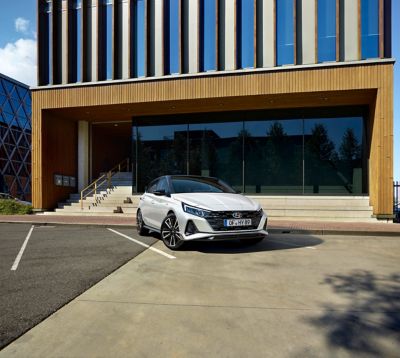 Hyundai i20 N Line est garée devant un bâtiment moderne.