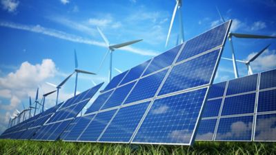 Solar panels and wind turbines on a field.