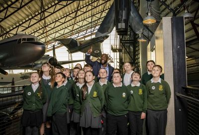 Group of students looking up at what their host is pointing to.