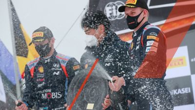 Hyundai Motorsport-piloot Thierry Neuville staat bij zijn auto, met zijn helm op het dak van de auto