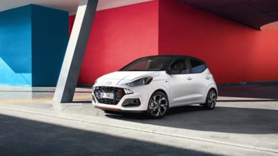 Hyundai i10 N Line parcheggiata di fronte a un muro rosso