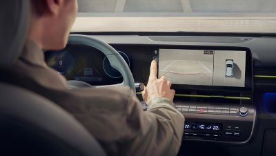 A man with a yellow shirt is getting out of the all-new Hyundai KONA through the driver’s side. 