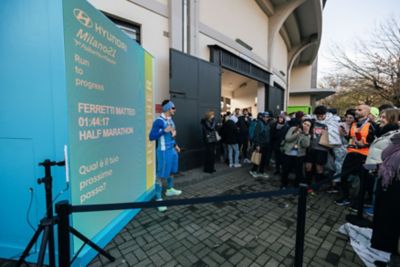 Hyundai mechanic inspecting the underside of a vehicle near the tire.