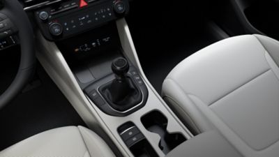 Wnętrze Hyundai TUCSON z widoczną gałką ręcznej skrzyni biegów.