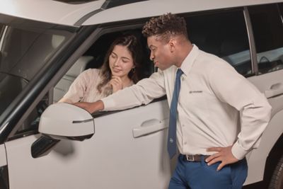 Hyundai mechanic inspecting the underside of a vehicle near the tire.