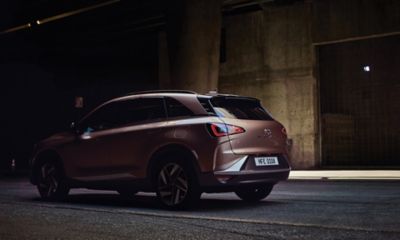 Afbeelding van atlete Femita Ayanbeku die langs een Hyundai NEXO loopt.