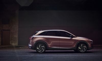 Women standing next to a Hyundai NEXO FCEV parked on a country road.