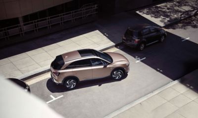Ein Hyundai NEXO parkt an einer sonnenbeschienenen innerstädtischen Straße.