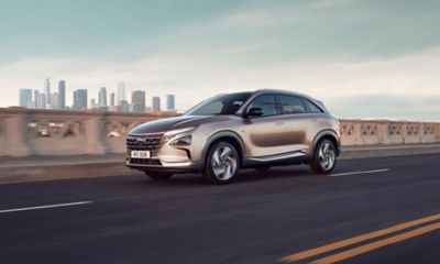 Vue latérale de Hyundai NEXO roulant dans une rue.