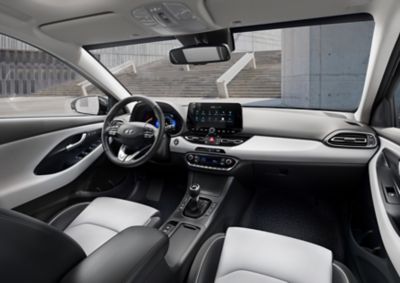 Přední interiér modelu Hyundai i30 Fastback při pohledu ze zadního sedadla.
