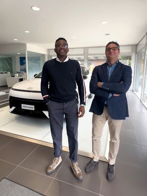 Due dipendenti in piedi in showroom davanti ad una KONA Hybrid bianca