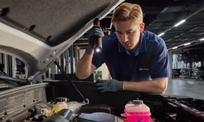 Hyundai-tekniker inspekterar fordonets motorrum med arbetslampa inför besiktning.