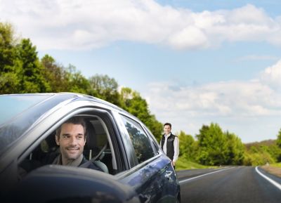 A man driving away in his vehicle