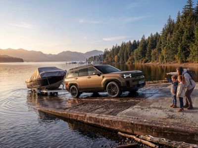 Hyundai SANTA FE reversing a boat trailer to the water.