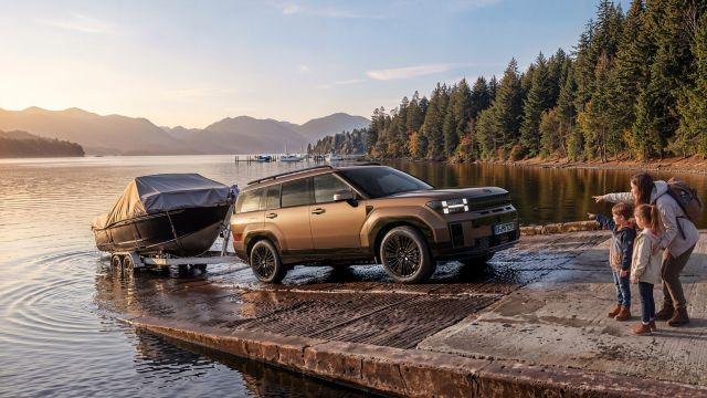 Hyundai SANTA FE reversing a boat trailer to the water.