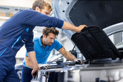 Pracownicy serwisu Hyundai otwierający maskę samochodu