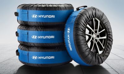 Hyundai original däckförvaringspåsar för fyra hjul staplade på golv.