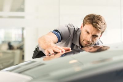 Technicien inspectant une voiture.