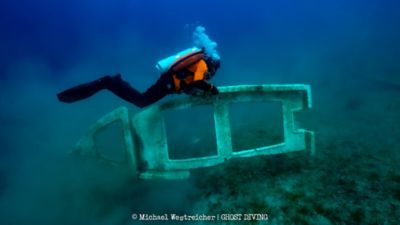 Plongeur de l’ONG Ghost Diving récupérant des déchets sous les eaux.