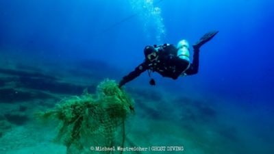 Nurek z Ghost Divers odzyskuje zagubioną sieć rybacką pod wodą.