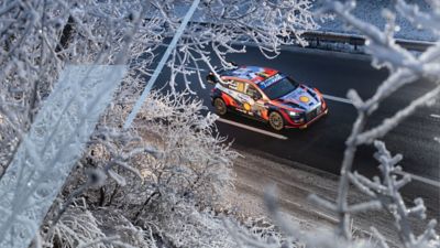 Hyundai i20 N WRC rajdowy samochód wyścigowy pędzący zimą po drodze..