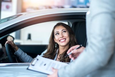 Kobieta za kierownicą samochodu, wyjeżdżająca z salonu Hyundai.