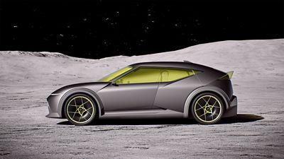 Hyundai Concept THREE on a moon-like surface under a starry sky, with detailed yellow-accented wheels.